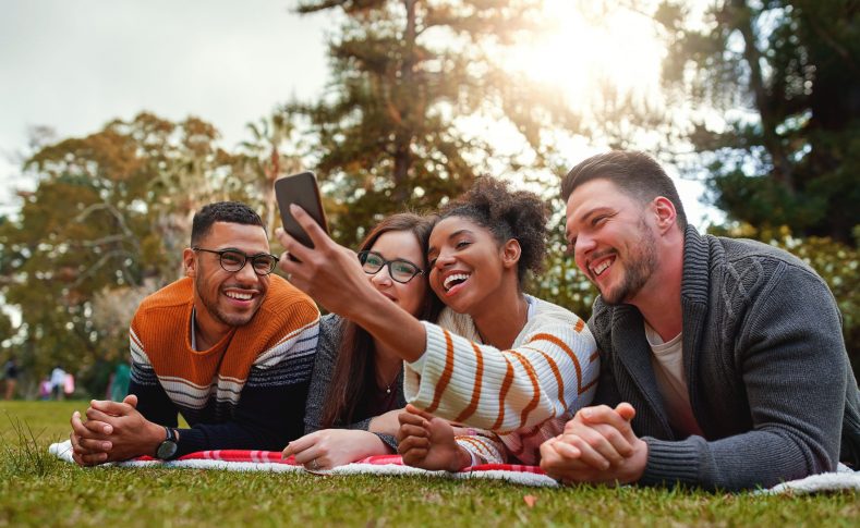 Diverse group of happy friends taking selfie in the park